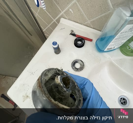 חלקי ברז ישנים על כיור בחדר אמבטיה